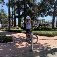 A person on a bike holding up a white plate. 