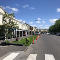 Picture of workers unfurling artificial turf in front of a hospital in Melbourne, Australia. 