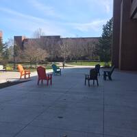 Six empty multicolored chairs. 