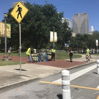 Protestors outside an entrance to Duncan Plaza in New Orleans, Louisiana holding a banner with Uncle Sam in a face mask with text saying, "I want you to die for the economy." 