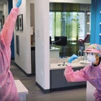 Two people in pink personal protective equipment at a dentist office. 