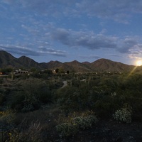 The moon rising near some mountains. 