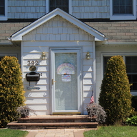 Residential house with a rainbow in the front screen door.  