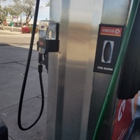 A gas station pump at Circle K that has a hand sanitizer dispenser mounted on the left side with a dispenser for fuel gloves next to it. 