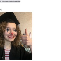 A person is wearing a graduation cap and gown and has on clown makeup. They are giving a thumbs up. 