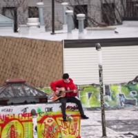 A person playing guitar on top of a building. 