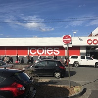 A line of people outside a supermarket. 