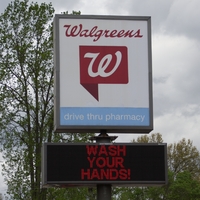 A sign outside a Walgreens reading "wash your hands".