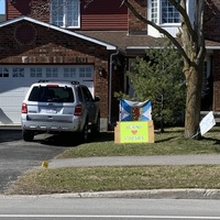 Image of a sign in a front yard which says be kind, stay safe.