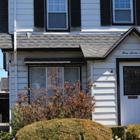 Residential house with a rainbow in the front window. 