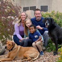 A family posing with two dogs. 