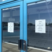 Photo of two signs on a business door reading "sorry we are closed until further notice".