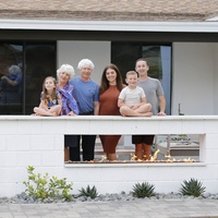 A family posing for a picture in front of a house. 