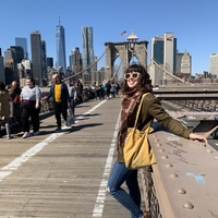 a woman in sunglasses smiling on a bridge