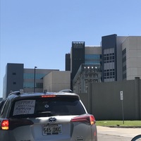 Silver SUV with a sign in the back window with text saying, " Support Whole Foods and Amazon strikes."