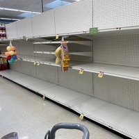 Empty row of shelves in an aisle at a supermarket. 