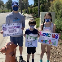 This is a picture of an Asian man and two children holding signs that urge the reader to help combat attitudes of Asian hate in wake of the COVID-19 Pandemic. 