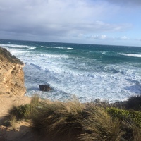 This is a picture of ocean waves approaching a small cove at a beach. 