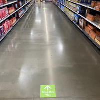 A sign on the floor indicting which way to travel down an aisle at a grocery store.