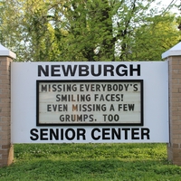 A senior center sign reading "Missing Everybody's Smiling Faces! Even Missing A Few Grumps, Too".