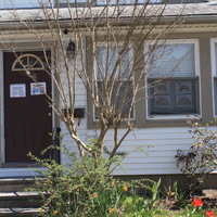 Residential house with a rainbows in the front window and on the front door. 