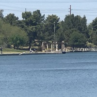 Photograph of people fishing at a lake. 