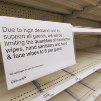 A sign on a store shelf reading "Due to high demand and to support all guests, we will be limiting the quantities of disinfectant wipes, hand sanitizer and hand and face wipes to 6 per guest".