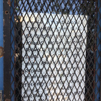 A closed sign on a grated door. 