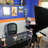 A laptop set up on a desk behind a light. 