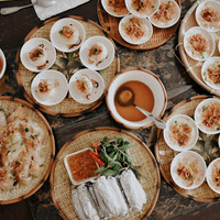 This is a picture of several platters of food set on a table, ready to eat. 