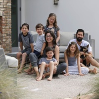 People sitting down, one holding a dog. 