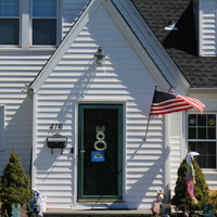 Residential house with a rainbow in the front screen door. 