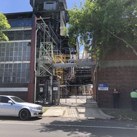 Picture of people wearing masks in front of a factory in Australia. 