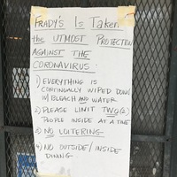 A piece of paper is taped on the front of a door to a store and says: FRADY'S IS TAKEN THE UTMOST PROTECTION AGAINST THE CORONAVIRUS: 1) EVERYTHING IS CONTINUALLY WIPED DOWN WITH BLEACH AND WATER. 2) PLEASE LIMIT TWO (2) PEOPLE INSIDE AT A TIME. 3) NO LOITERING. 4) NO OUTSIDE/INSIDE DINING. 