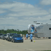 Photo of several cars in line for a drive-thru COVID testing site.