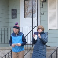 Two elderly people in front of a house. 