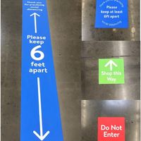 Image of floor signs in Walmart which read please keep six feet apart, shop this way and do not enter.