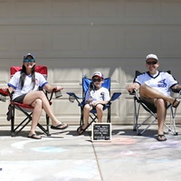 A family sitting on lawn chairs. 