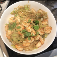 A photo of a plate of food with noodles and shrimp.