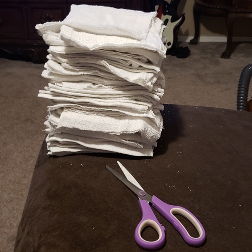 Towels and scissors on a couch. 