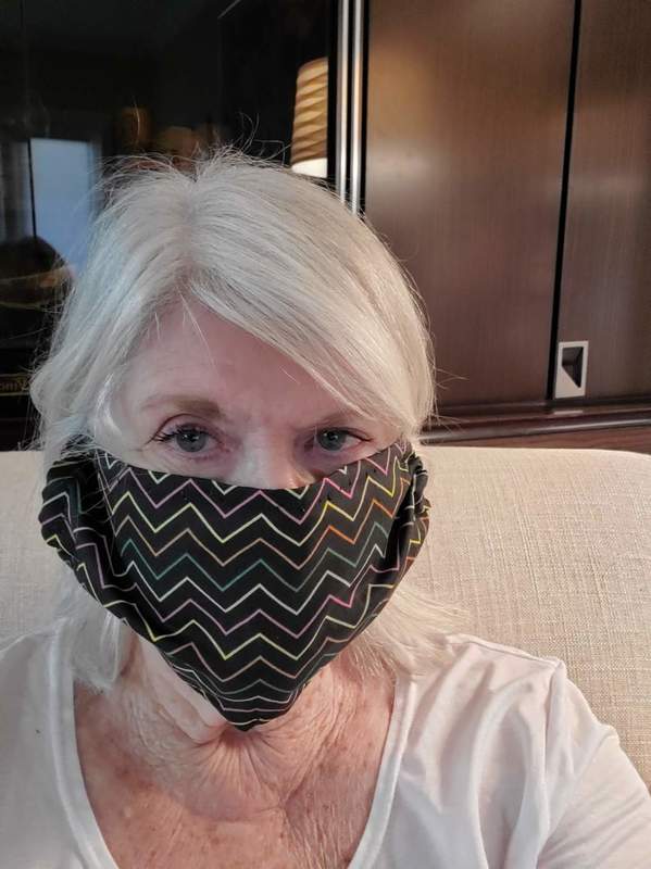 A person sitting down wearing a mask. 