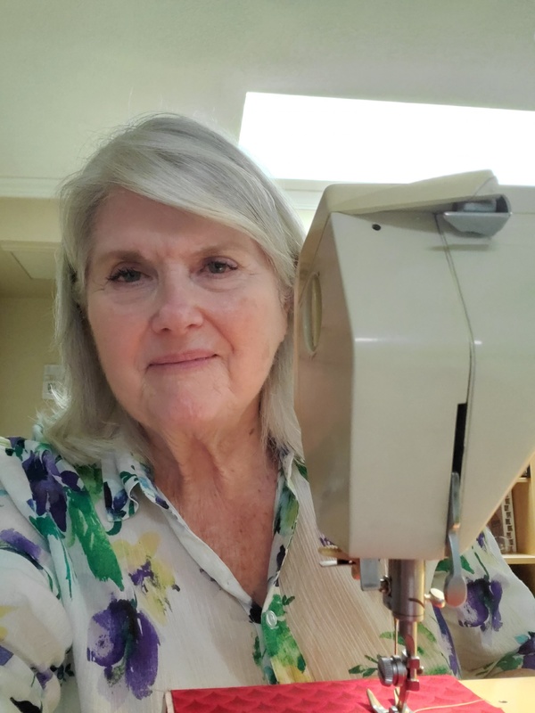 A person sitting behind a sewing machine.