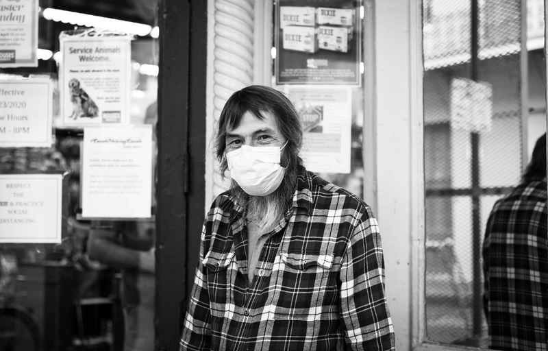 Black and white photo of a person wearing a face mask. 