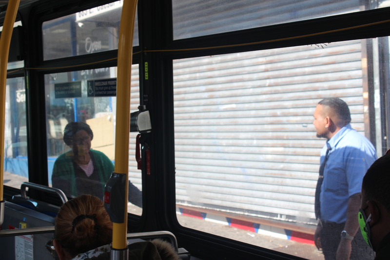 Two people standing outside of a bus. 