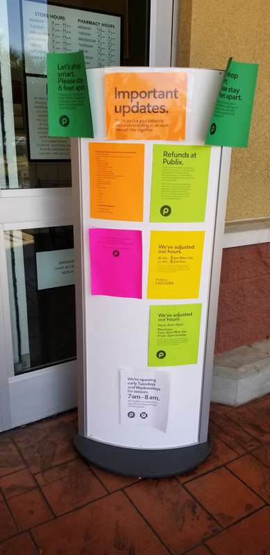 A sign in front of a grocery store that says: Important Updates. There are various signs that talk about refunds, hours, and social distancing. 